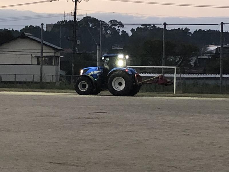 薄暗い中、大型トラクターでの草刈り