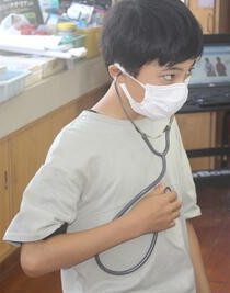 聴診器で拍動数を調べています。