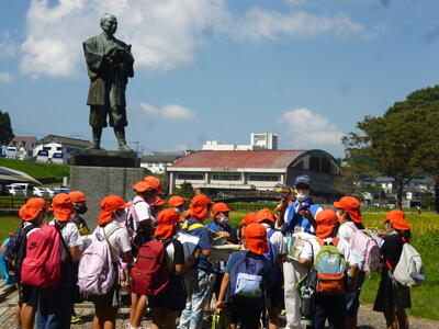 布田保之助の像でガイドさんの話を聞く